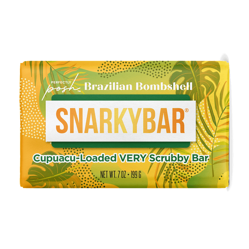 The Perfectly Posh Brazilian Bombshell Cupuacu-Loaded VERY Scrubby Snarky Bar is a rectangular exfoliating body bar in yellow, green, and white leafy tropical packaging for a moisture-rich scrub.