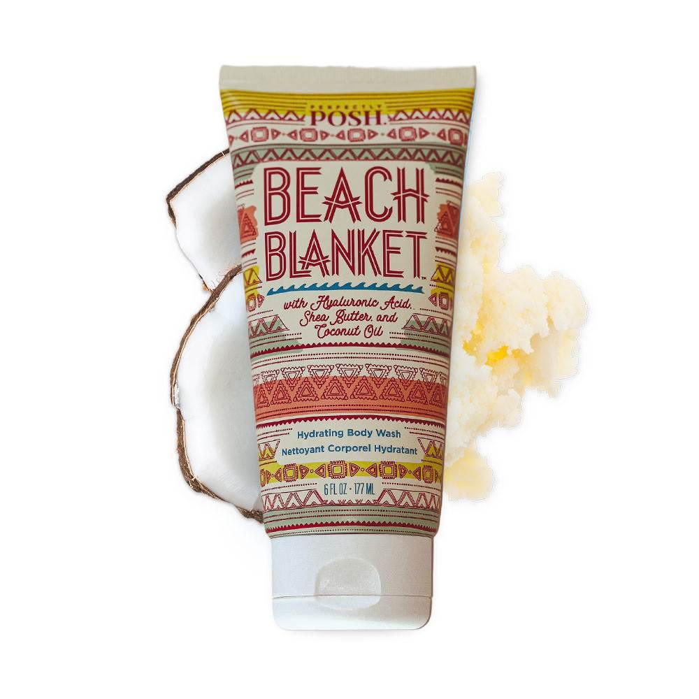 A tube of Perfectly Posh Beach Blanket Hydrating Body Wash with a vibrant tribal design is pictured beside coconut shell and shea butter, emphasizing its creamy formula and natural ingredients.
